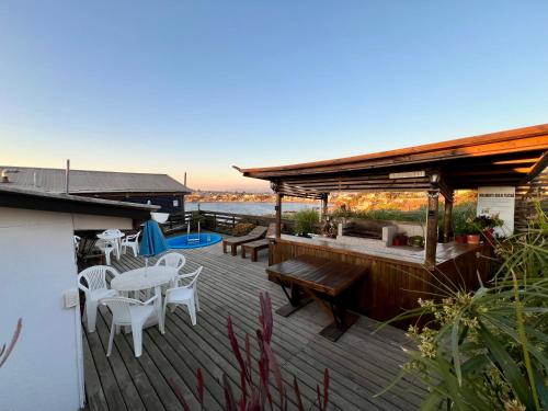 Una terraza de madera con una mesa y sillas. en Cabañas DeMAICO, en Quintero