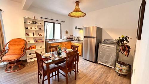 a kitchen with a table and a stainless steel refrigerator at Departamento Guayacan Tepoztlan in Tepoztlán