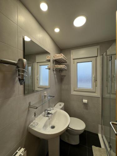 a bathroom with a sink and a toilet and a mirror at Apartamentos Olga Cantabria 2 in Polanco