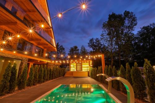 a pool in the backyard of a house at night at Białka SPA & Resort, Odkryj-Białkę in Białka Tatrzańska