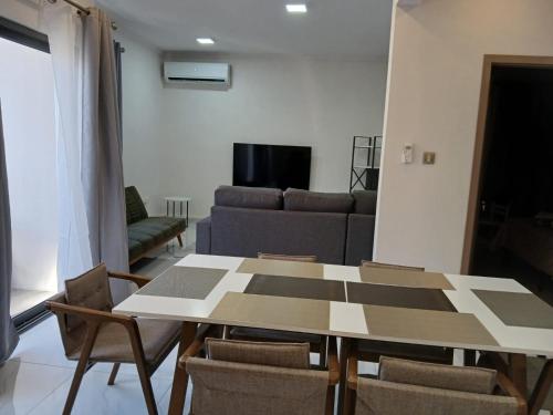 a living room with a table and chairs and a couch at Anuya B1 in Flic-en-Flac