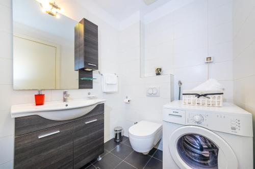 a bathroom with a washing machine and a sink at Apartman Diana in Zadar