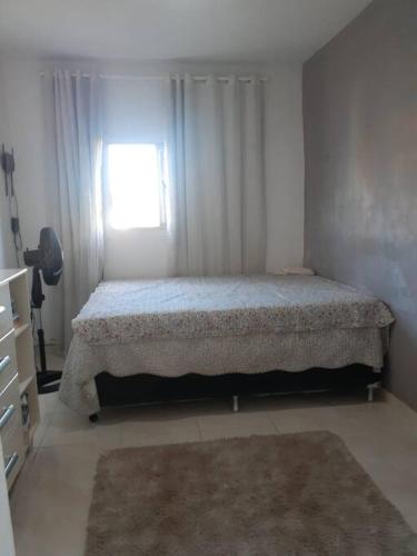 a bedroom with a bed and a window at Apartamento no Centro in Patos