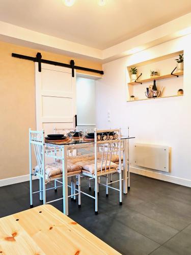 une salle à manger avec une table et des chaises dans l'établissement Maison des Palmiers - Bord de mer et campagne, à Port-en-Bessin-Huppain