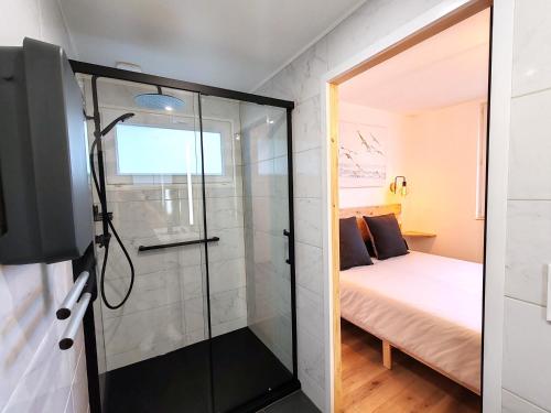 une petite salle de bain avec douche et un lit dans l'établissement Maison des Palmiers - Bord de mer et campagne, à Port-en-Bessin-Huppain