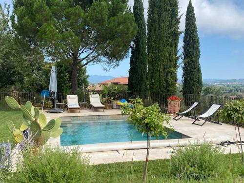 - une piscine dans une cour avec des chaises et des arbres dans l'établissement Ferme gite de la Garrigue, à Maraussan