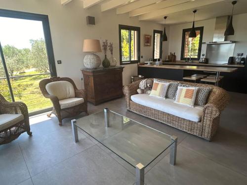 un salon avec un canapé et une table en verre dans l'établissement Ferme gite de la Garrigue, à Maraussan