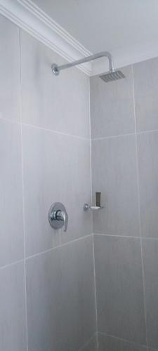 a shower with a shower head in a bathroom at Mathwala Guesthouse in Vanderbijlpark
