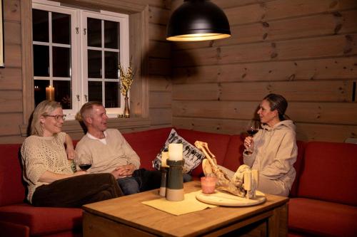 three people sitting on a couch in a room at Family Lodge in Stryn in Stryn
