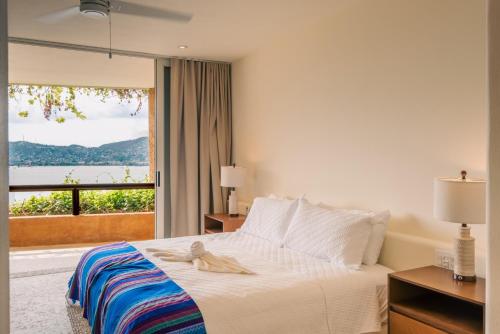 une chambre d'hôtel avec un lit et une fenêtre dans l'établissement Armadillo Living Villas, à Zihuatanejo