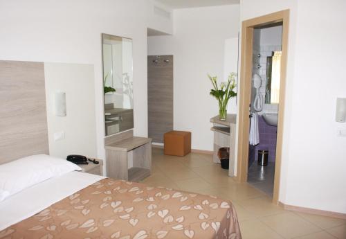 a bedroom with a bed and a bathroom at Hotel Villa Enea in Cattolica