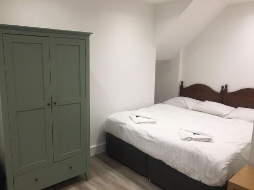 a bedroom with a green cabinet and a bed at Hadleigh Hotel in Eastbourne