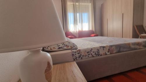 a bedroom with a bed and a lamp on a table at Sulla via del Mare Room I.U.N R5045 in Terralba