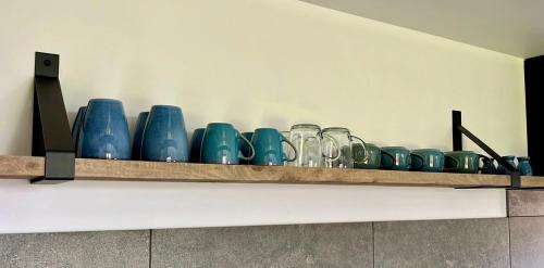 a row of blue glassases sitting on a shelf at Zilte zee in Geersdijk