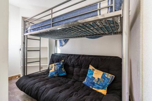 - un canapé noir assis sous un lit superposé dans l'établissement Coquet, terrasse, BBQ, Clim, parking, proche plage, à Sète