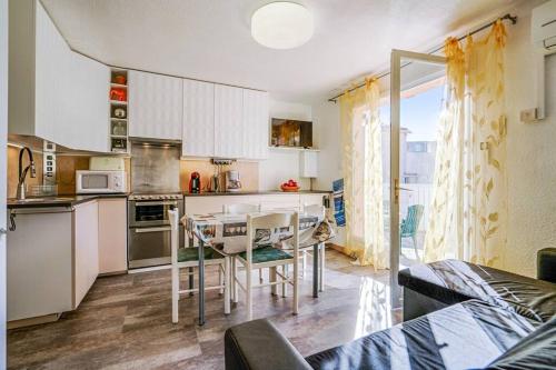 une cuisine avec une table et des chaises dans une pièce dans l'établissement Coquet, terrasse, BBQ, Clim, parking, proche plage, à Sète