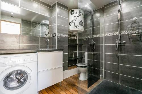 une salle de bain avec machine à laver et toilettes dans l'établissement Coquet, terrasse, BBQ, Clim, parking, proche plage, à Sète