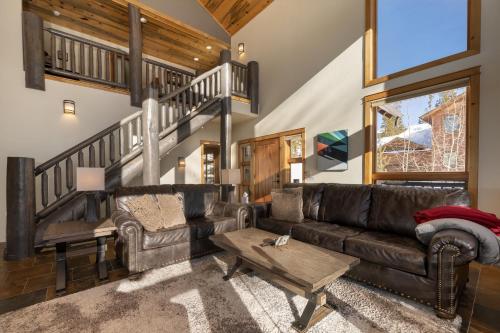 a living room with a leather couch and a table at Dreamcatcher at Lakota home in Winter Park