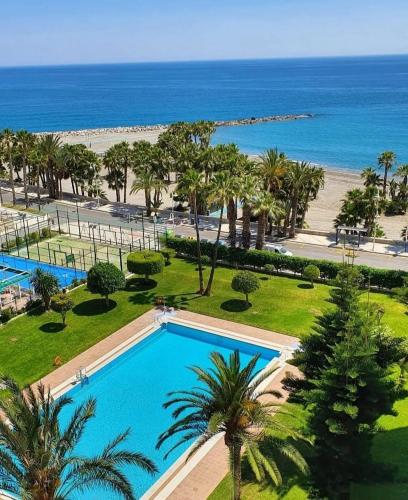 an aerial view of a resort with a swimming pool and the beach at Atico estudio en 1°linea Almuñecar in Almuñécar
