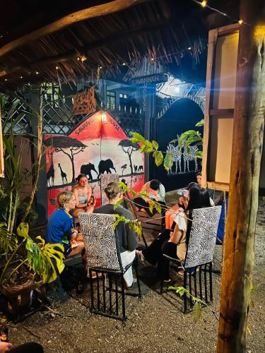 a group of people sitting at a table in a restaurant at Savannah House in Arusha