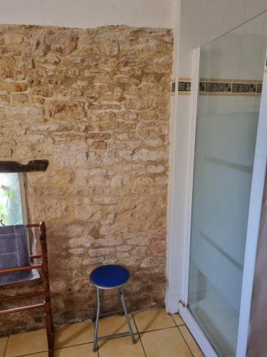 une pièce avec un mur de briques, une chaise et une porte vitrée dans l'établissement Little House in the Dordogne, à Salignac Eyvigues