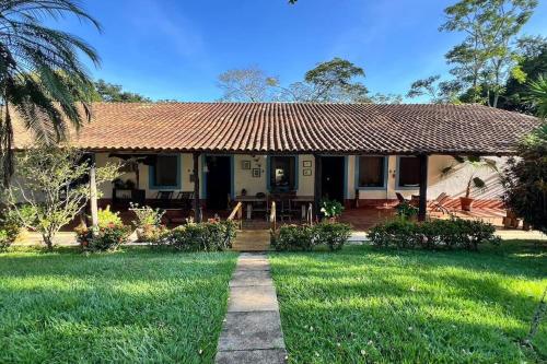 uma casa com um jardim relvado com um caminho em Fazenda Lagoinha em Chapada dos Guimarães