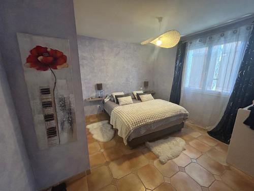 - une chambre avec un lit orné d'une fleur sur le mur dans l'établissement VILLA Méditerranéenne calme, PISCINE sans vis à vis, à Boujan-sur-Libron