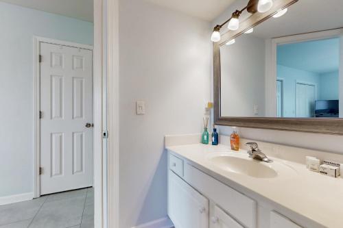 un baño con lavabo y espejo en Charm of the Canal, en Carolina Beach