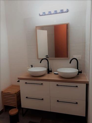 une salle de bain avec deux lavabos et un miroir dans l'établissement Maison bois récente, à Lantic