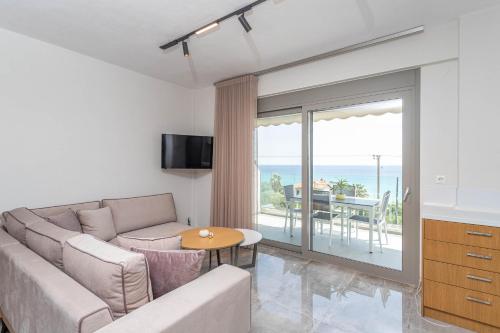 a living room with a couch and a table at Alexmare SeaView House Mola Kaliva in Mola Kalyva