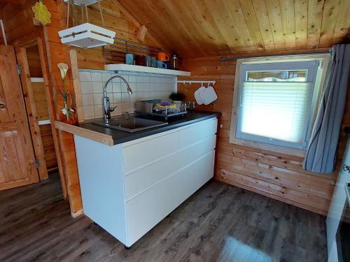 a kitchen with a sink and a window in a cabin at Bungalow in Klein Str mkendorf in Klein Strömkendorf