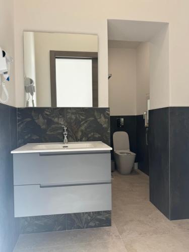 a bathroom with a white sink and a toilet at Montecristo B&B in Grosseto