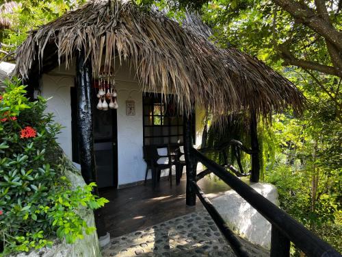 a small house with a straw roof at Quetzal Dorado Eco-Lodge by Mareygua in El Zaino