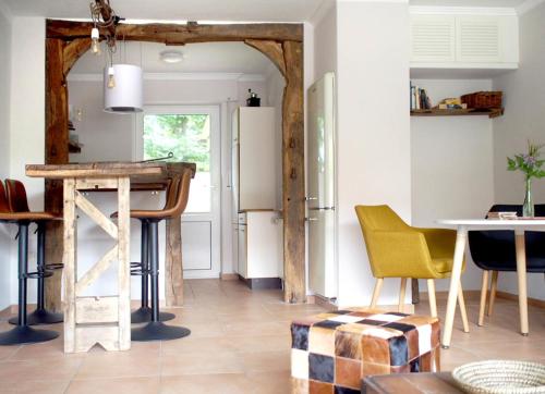eine Küche mit einem Kühlschrank sowie einem Tisch und Stühlen in der Unterkunft Ferienhaus mit Sauna "Waldrausch" - An der Rehwiese 1 RE01 in Sögel