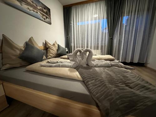 two swans laying on a bed in a bedroom at Ferienwohnung AltePost in Bad Aussee