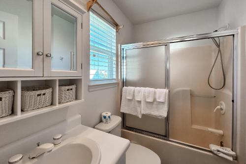 Un baño blanco con lavabo y ducha. en Blue Lagoon, en Gulf Shores