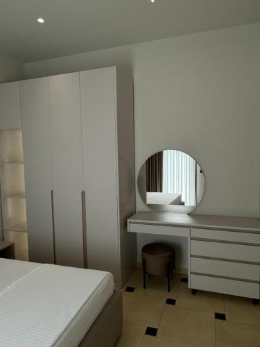 a bedroom with a bed and a desk with a mirror at Aayan Apartments in Vlorë