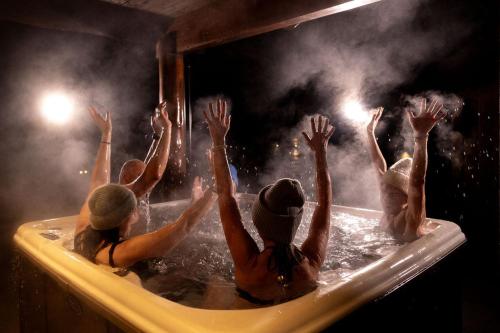 a group of people in a bathtub with their hands up at Family Lodge in Stryn in Stryn