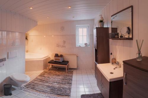 a bathroom with a tub and a toilet and a sink at Ferienhaus Castle View Quedlinburg in Quedlinburg