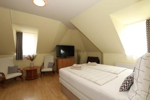 a bedroom with a white bed and a tv at Villa Nova in Hévíz