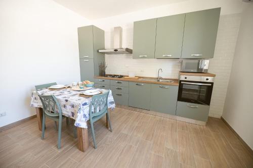 a kitchen with a table with chairs and a sink at La Raganella D'Oro in Pico