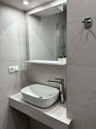 a bathroom with a sink and a mirror at Apartments and Rooms Nikola in Omiš