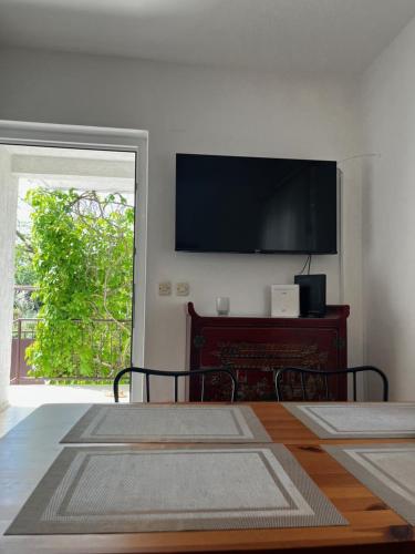 Un dormitorio con un televisor de pantalla plana en la pared. en Anna's holiday home, en Supetar