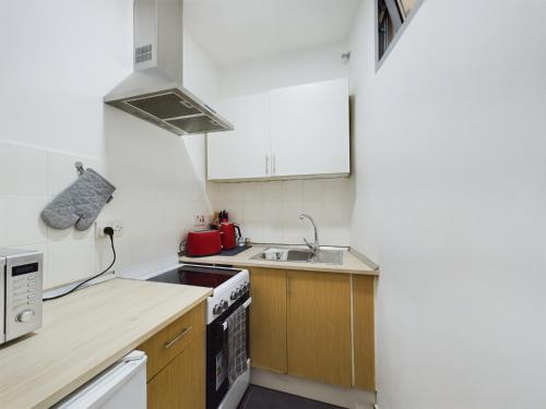 a small kitchen with a sink and a stove at Hidden Gem Hideaway Retreat in Central Town Area with AC in Gibraltar