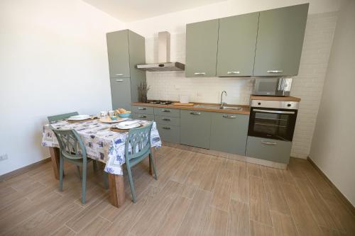 a kitchen with a table with chairs and a sink at La Raganella D'Oro in Pico