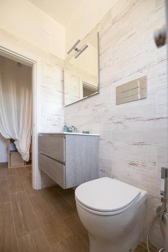 a bathroom with a white toilet and a sink at La Raganella D'Oro in Pico