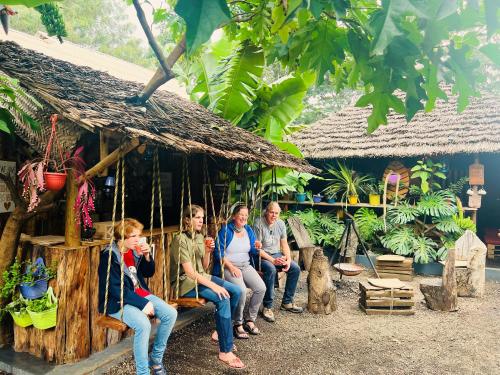 a group of people sitting on a porch of a hut at Serengeti Villa in Arusha