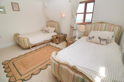 a bedroom with two beds and a couch and a window at Lanyon in St Ives