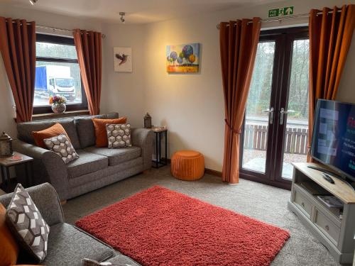 a living room with a couch and a tv at 5 The Galleries in Spean Bridge