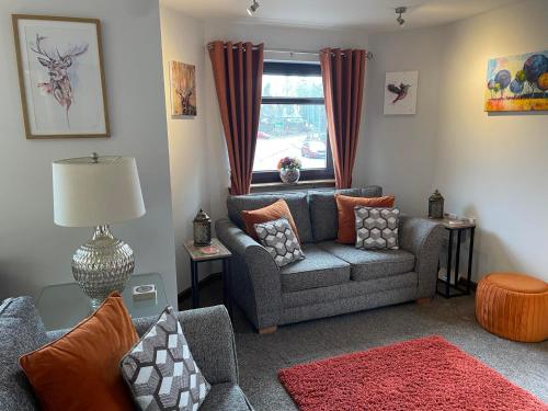 a living room with a couch and a window at 5 The Galleries in Spean Bridge